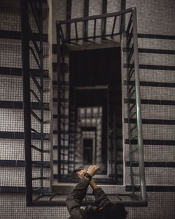 Rear view of man standing against building in city