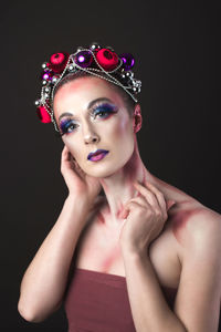 Close-up portrait of young fashion model against black background