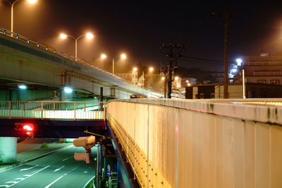 Illuminated bridge against sky at night