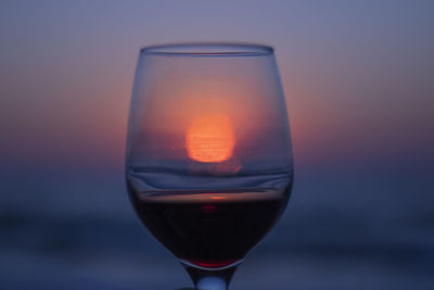 Close-up of wine in glass against sunset