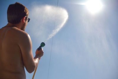 Low angle view of shirtless man against sky