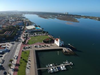 High angle view of town by sea against sky