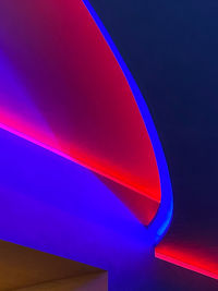 Low angle view of illuminated rainbow against blue sky