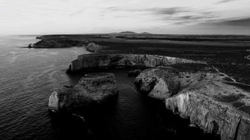 High angle view of rocks by sea against sky