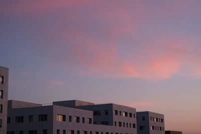 Low angle view of buildings against sky at sunset