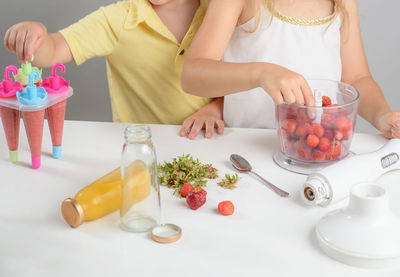 Midsection of woman holding ice cream on table