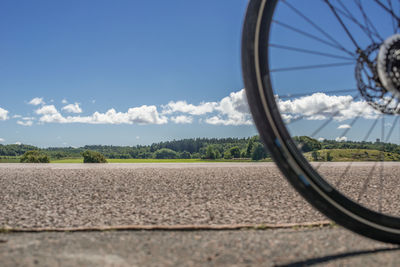 Close-up of bicycle on field against sky