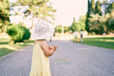 Side view of cute girl standing on road