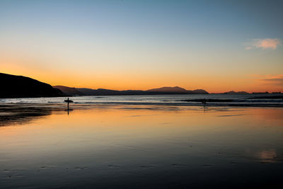 Scenic view of beach against sky during sunset