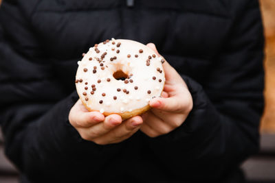 Midsection of woman holding donut