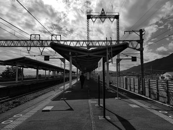 Man on railroad track against sky