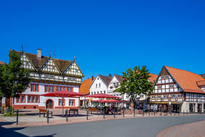 Houses and buildings against clear blue sky