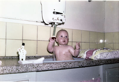 Full length of shirtless boy in bathroom