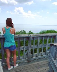 Rear view of woman on beach against sky