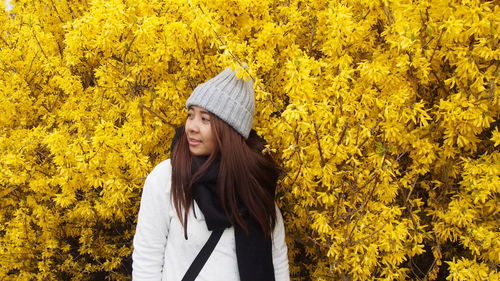 Woman standing by tree during autumn