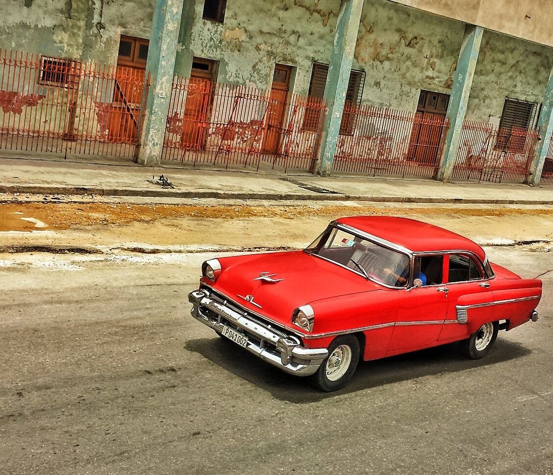 transportation, land vehicle, mode of transport, red, car, street, stationary, outdoors, road, day, no people, parked, built structure, parking, high angle view, architecture, wall - building feature, travel, building exterior, side view