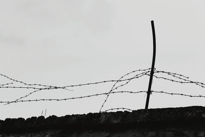 Low angle view of fence against sky