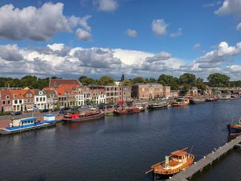 Boats moored at harbor against buildings in city