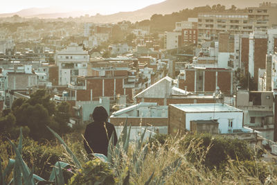 Rear view of man against buildings in city