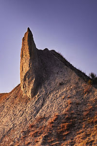 Low angle view of rock formation against clear sky