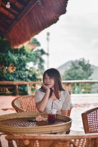 Portrait of young woman sitting in basket on table