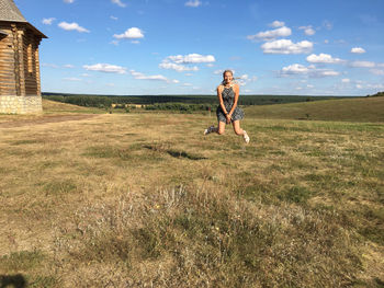 Woman standing on field against sky