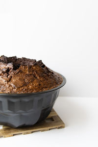 Close-up of chocolate cake on table against white background