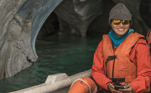 Portrait of a smiling young woman standing on rock