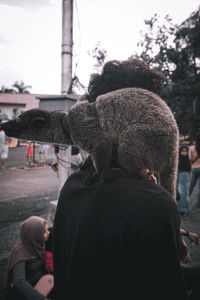 Rear view of man with arms outstretched against sky