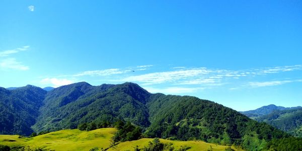 Scenic view of mountains against blue sky