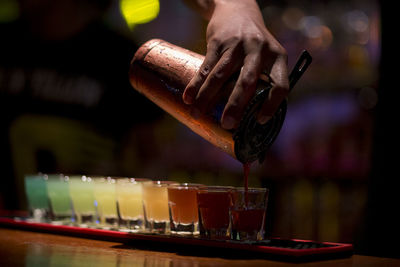 Midsection of person pouring wine in glass