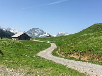 Road amidst green landscape against sky