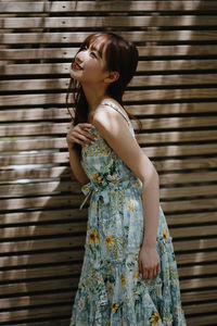 Young woman standing against wall