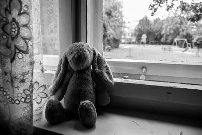 Close-up of teddy bear on window