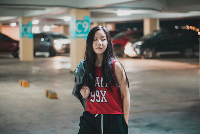 Portrait of young woman standing in city