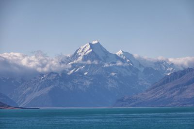 Scenic view of snowcapped mountains by sea against sky