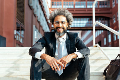 Portrait of young man standing against wall