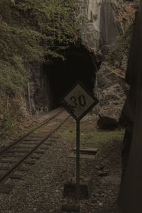 Road sign by railroad track