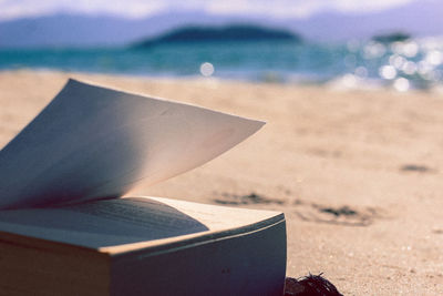 Close-up of open book on beach