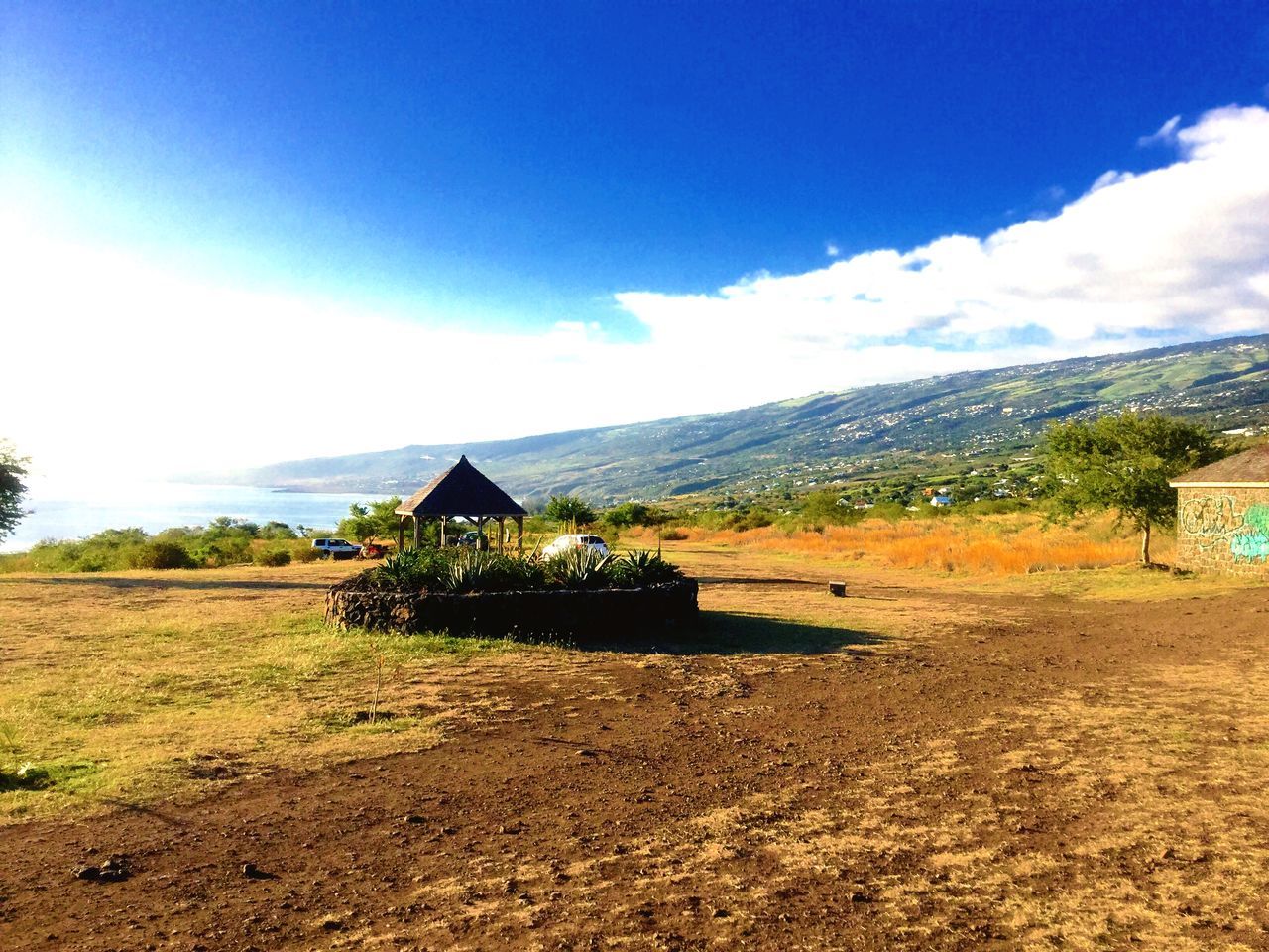 sky, mountain, house, building exterior, architecture, built structure, landscape, cloud - sky, tranquil scene, village, tranquility, cloud, beauty in nature, field, scenics, nature, blue, rural scene, residential structure, mountain range