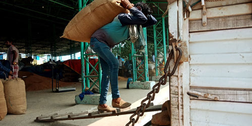 Rear view of man working on bridge in city