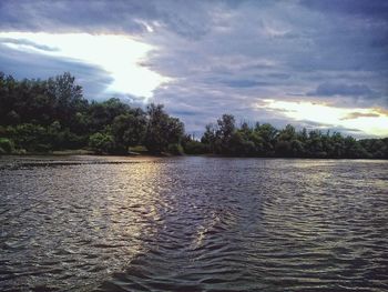 Scenic view of river against cloudy sky