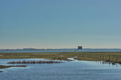 Scenic view of lake against clear blue sky