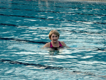 Portrait of a smiling woman swimming in pool
