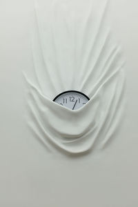 Directly above shot of clock on white fabric