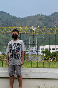 Rear view of young man standing against wall