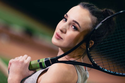 Close-up of young woman holding racket