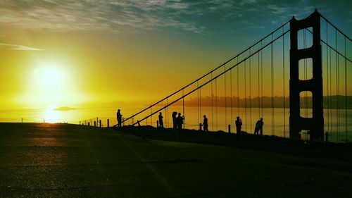 Silhouette of suspension bridge at sunset