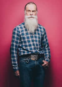 Portrait of man standing against red background