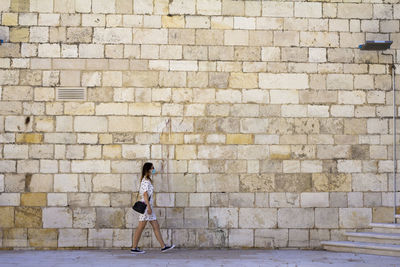 Woman standing against brick wall